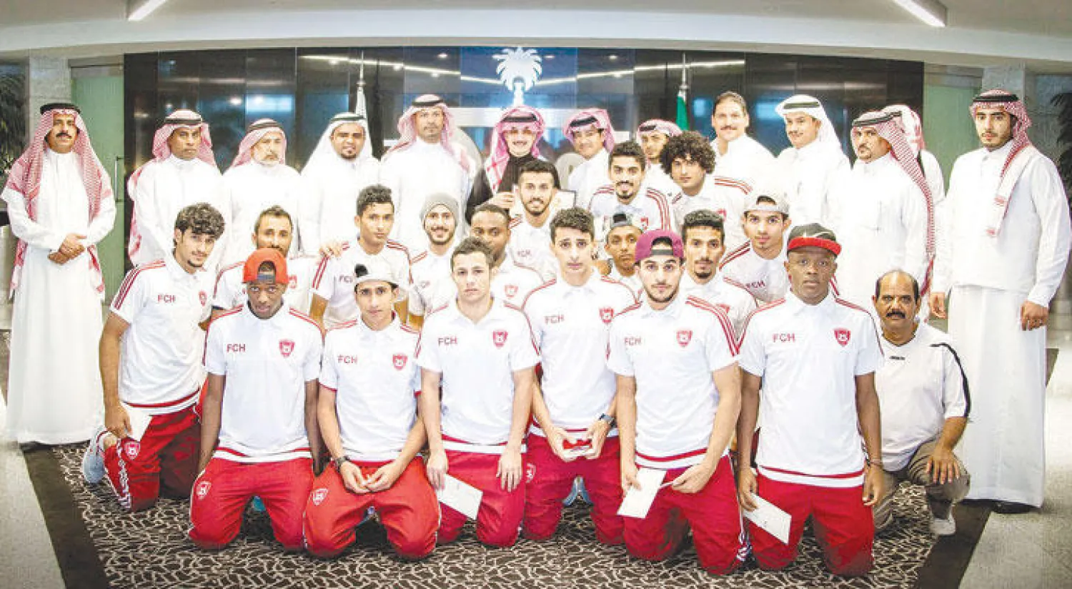 الأمير الوليد بن طلال في لقطة تذكارية مع إدارة ولاعبيه نادي حطين («الشرق الأوسط»)