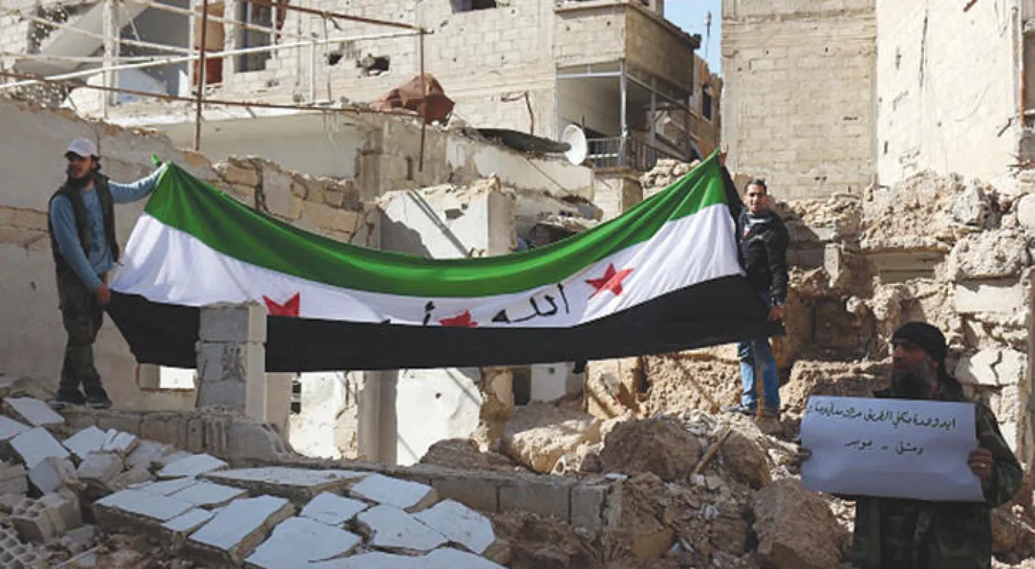 سكان بلدة جوبر بريف دمشق يعبرون عن احتجاجهم ضد نظام الأسد أمس ويرفعون علم الثورة السورية (غيتي)