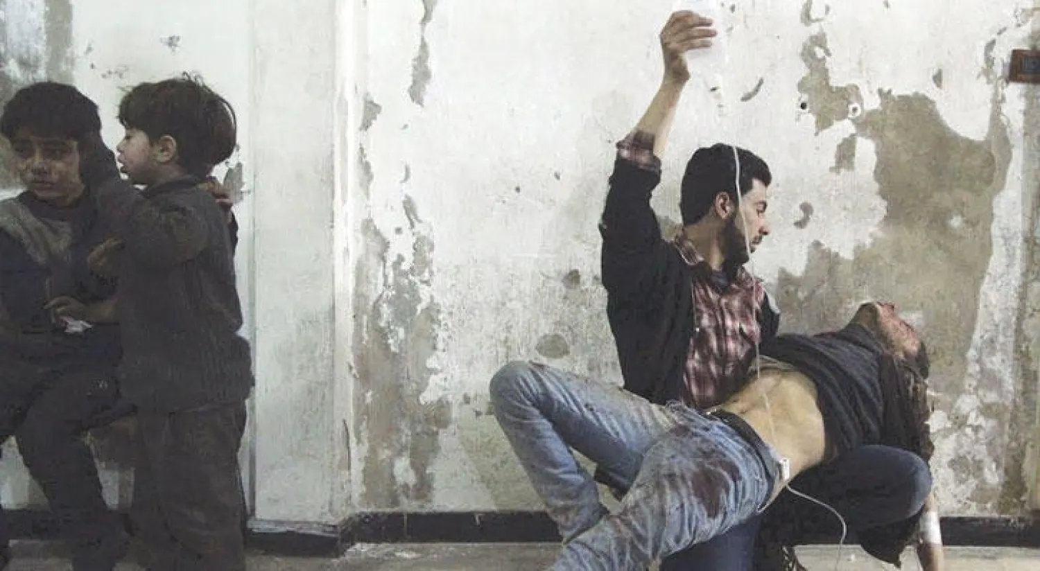 عامل في مجال الإغاثة الطبية يساعد مصابًا جراء قصف جوي على دوما في فبراير العام الماضي (رويترز)