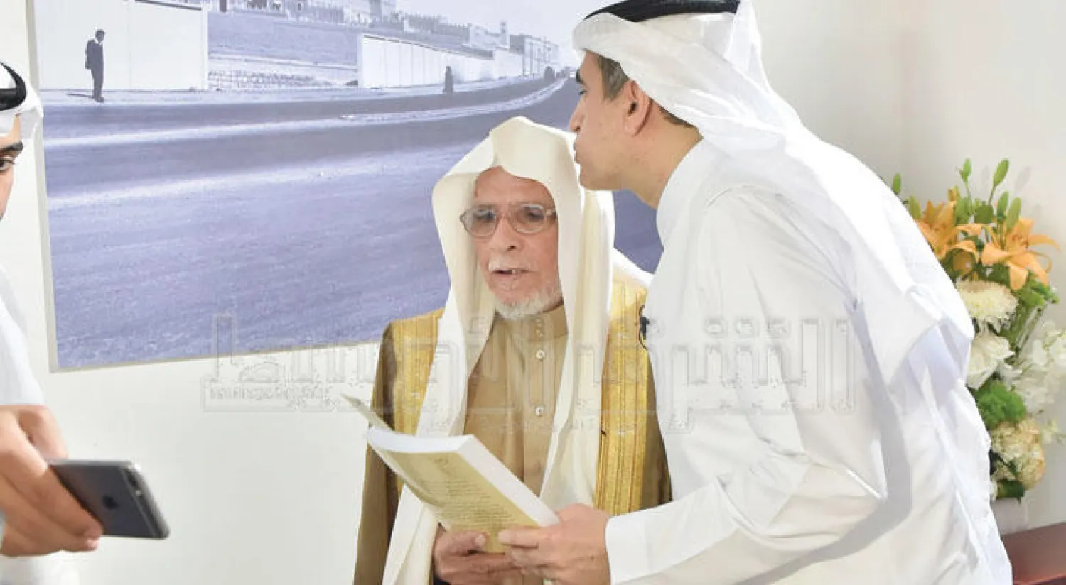 الدكتور عزام الدخيل يقبل رأس معلمه محمد اليوسف (تصوير: خالد الخميس)