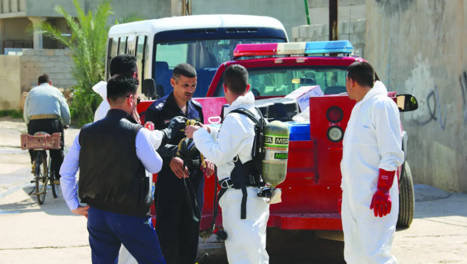 عناصر من المباحث الجنائية العراقية في قرية تازة بعد أنباء عن ضربها بمواد كيميائية من قبل {داعش} (أ.ف.ب)