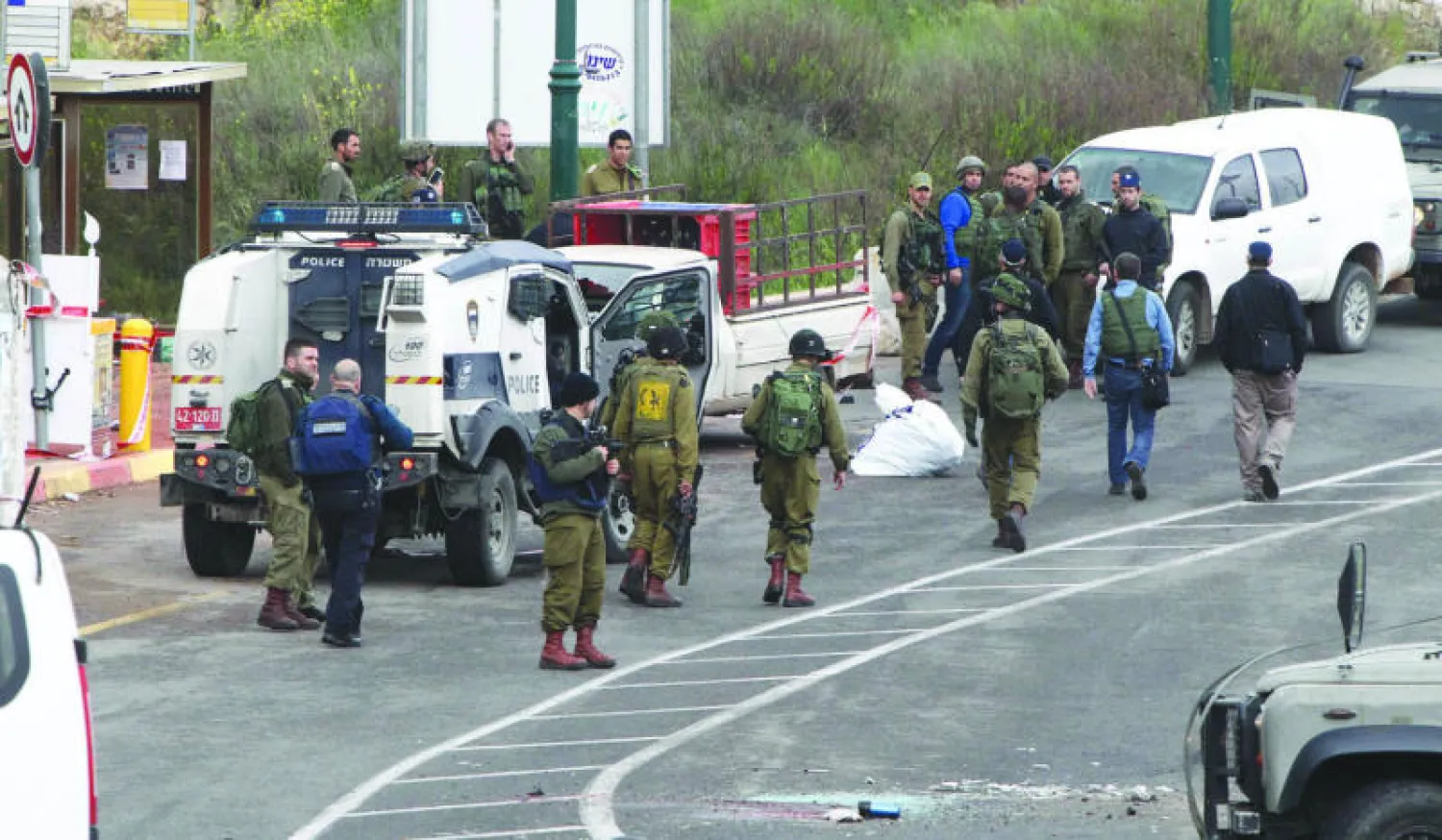 قوات الاحتلال الإسرائيلي في موقع الهجومين في مدخل مستوطنة كريات أربع قرب الخليل (أ.ف.ب)