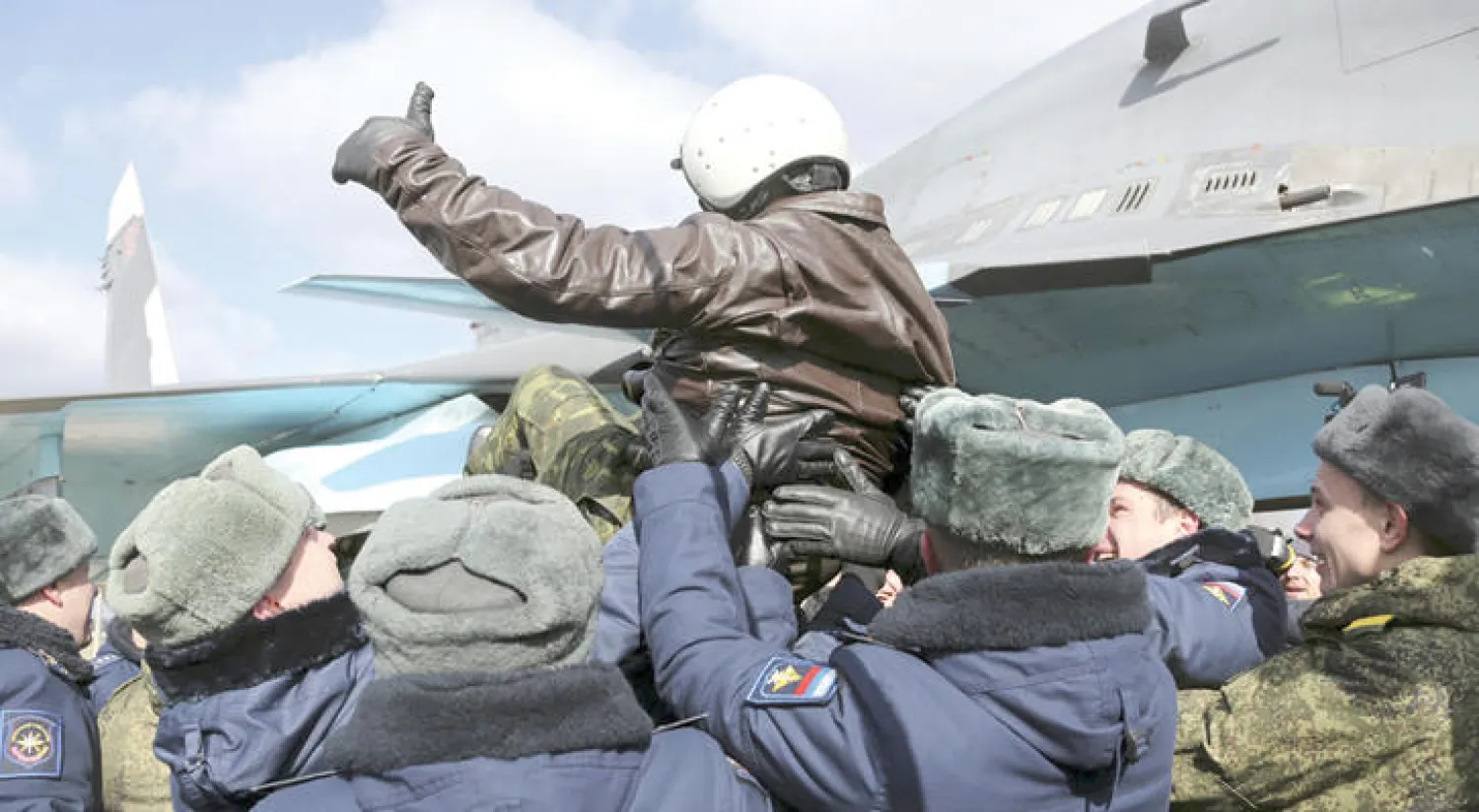عناصر من القوات الجوية الروسية يبدون فرحتهم بعد عودتهم إلى بلادهم أمس (أ.ب)