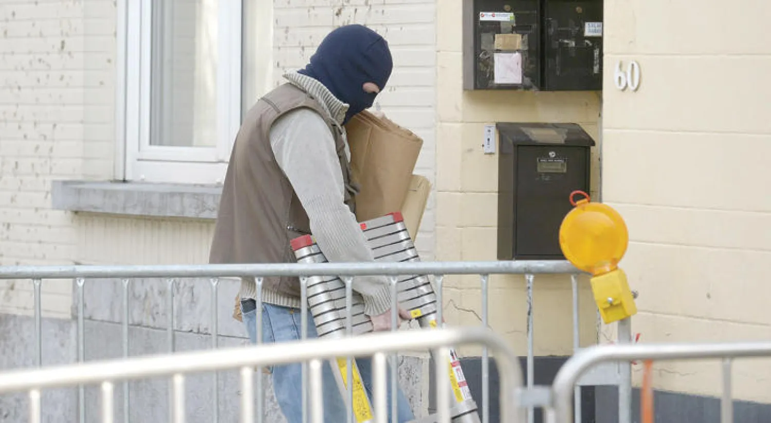 رجل أمن بلجيكي يصل إلى المنزل الذي داهمته الشرطة أول من أمس في بروكسل (أ.ف.ب)