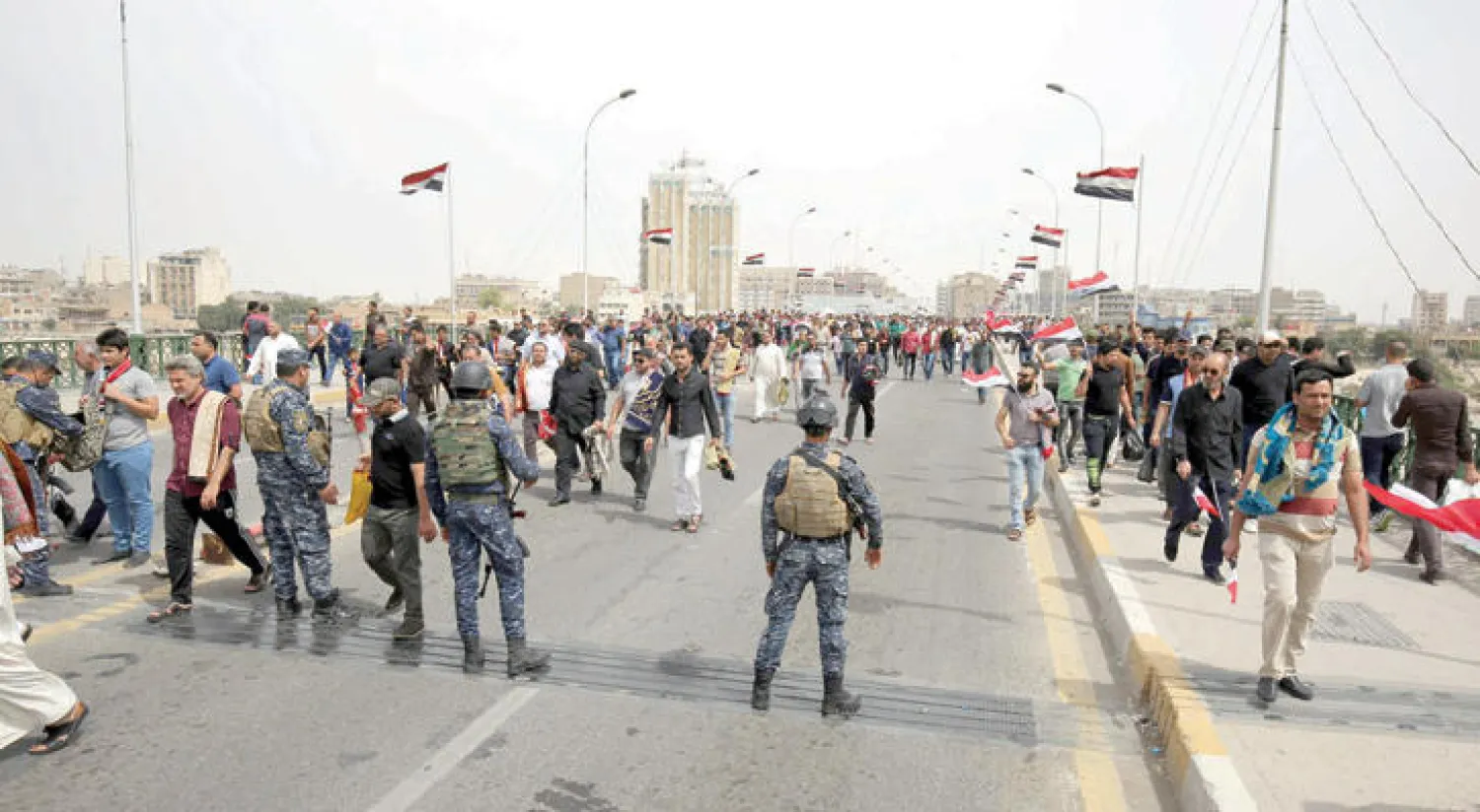 عناصر أمن يتولون حراسة مظاهرة لأنصار التيار الصدري في بغداد أمس (أ.ف.ب)