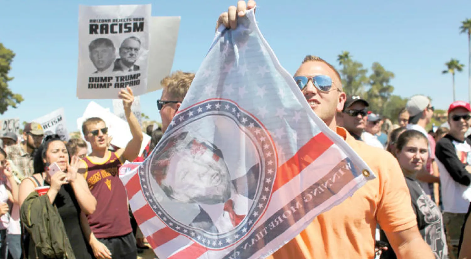 مؤيد للمرشح الرئاسي دونالد ترامب يحمل راية عليها صورة الأخير في فونتين بولاية أريزونا (رويترز)
