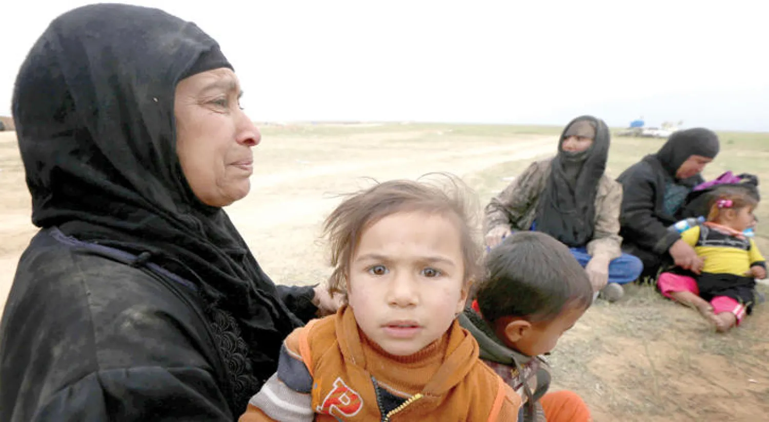 أفراد عائلة عراقية هاربة من معارك جنوب الموصل بعد وصولهم إلى نقطة تفتيش تابعة للبيشمركة في مخمور أول من أمس (أ.ف.ب)