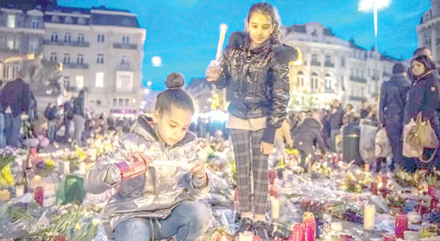 أطفال العاصمة البلجيكية بعد انتهاء الهجمات في لحظات تأبين الضحايا (نيويورك تايمز)