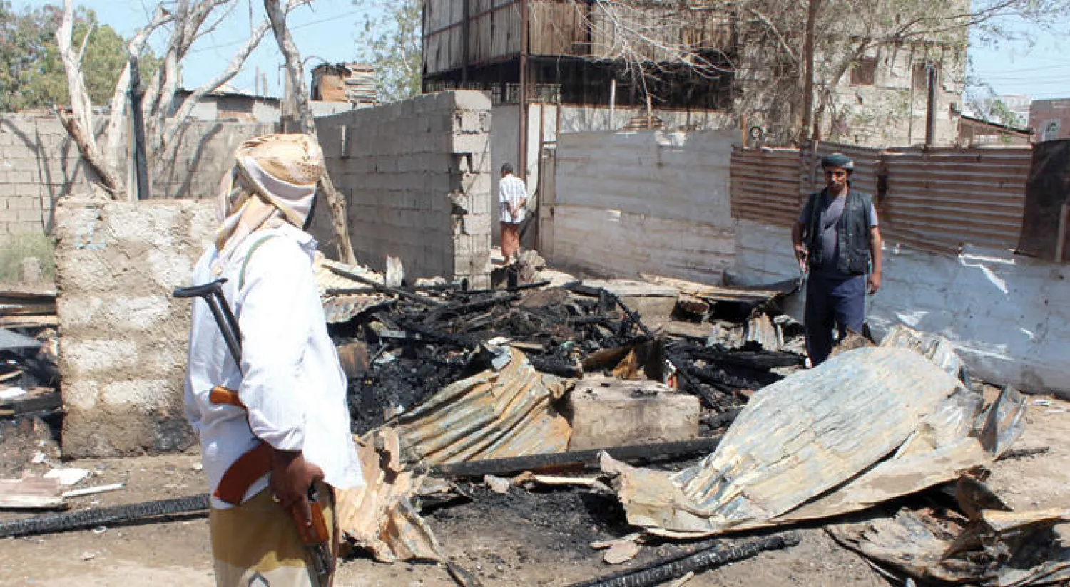 يمنيون يعاينون الدمار الذي نتج عن انفجار قنبلة تسبب في مقتل مسلحين تابعين لـ{القاعدة» كانوا يريدون نقلها في حي دار سعد جنوب عدن («غيتي»)