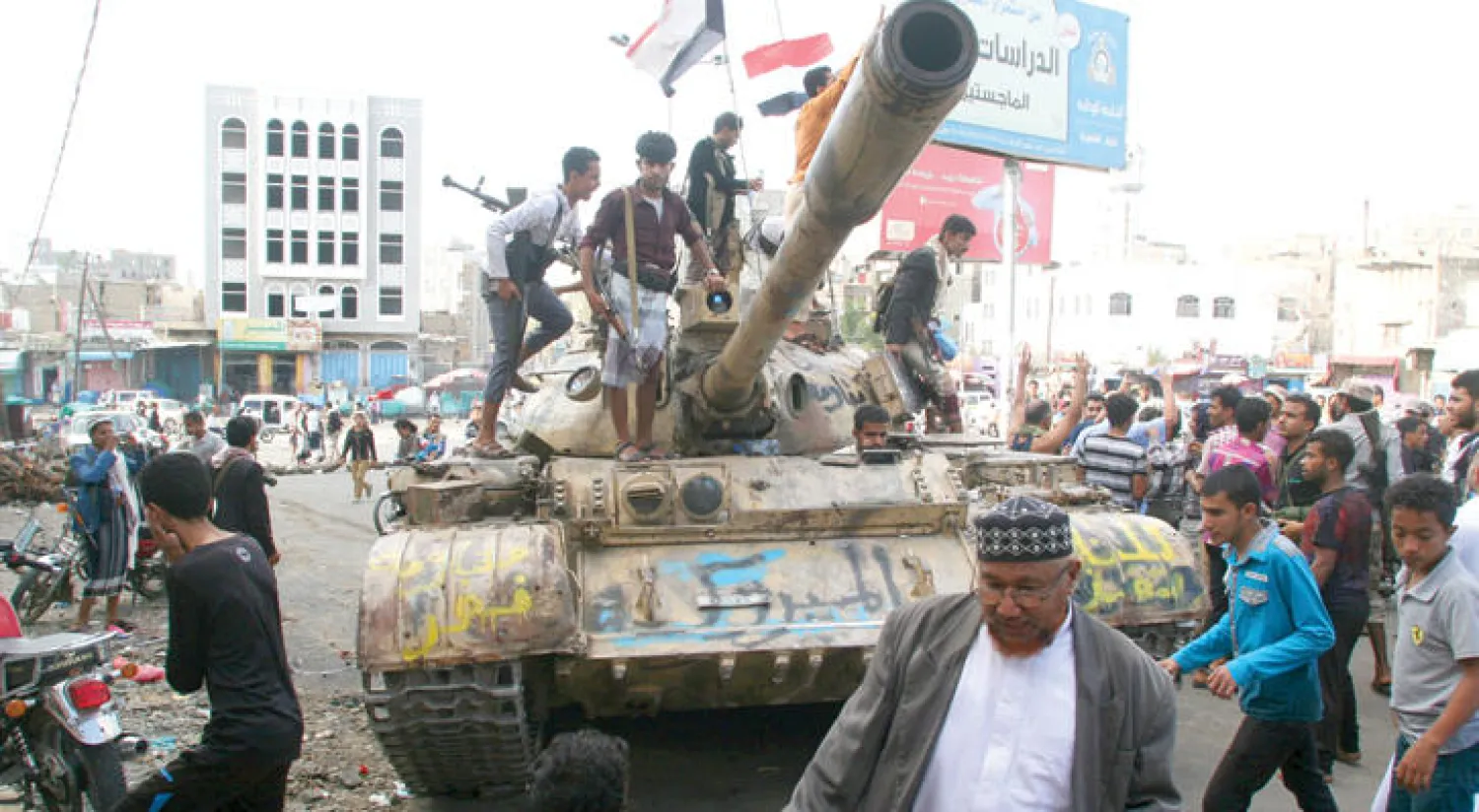 يمنيون يعتلون إحدى الدبابات التي شاركت  قبل أسبوعين في فك الحصار عن تعز الأمر الذي أجبر الميليشيات الانقلابية على القبول بمبدأ المفاوضات وتنفيذ القرارات الدولية (رويترز)