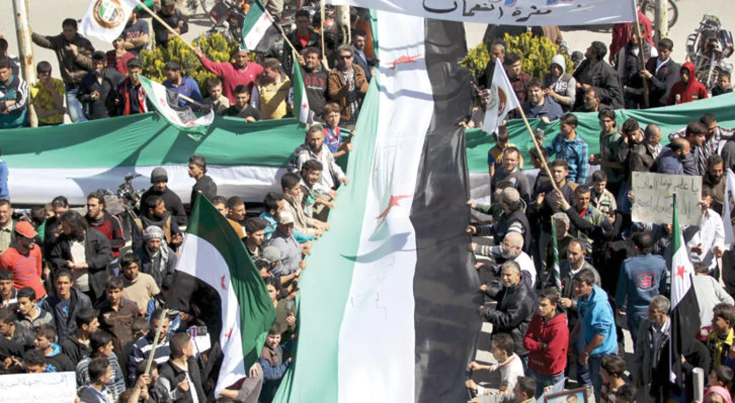 سوريون يتظاهرون ضد النظام في معرة النعمان في محافظة إدلب أمس (رويترز)