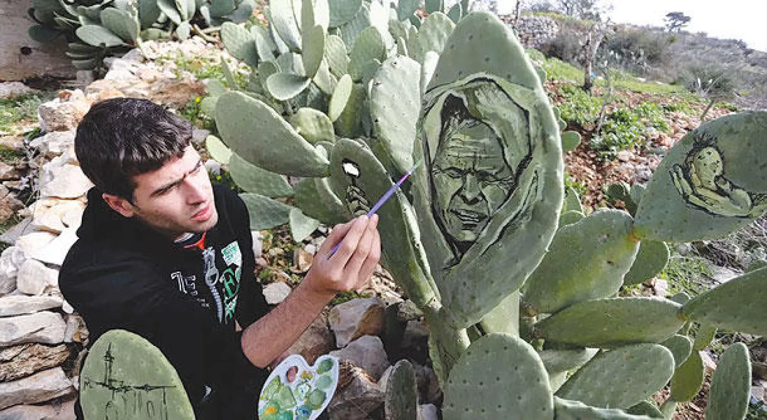 الفنان أحمد يرسم على شجر الصبار