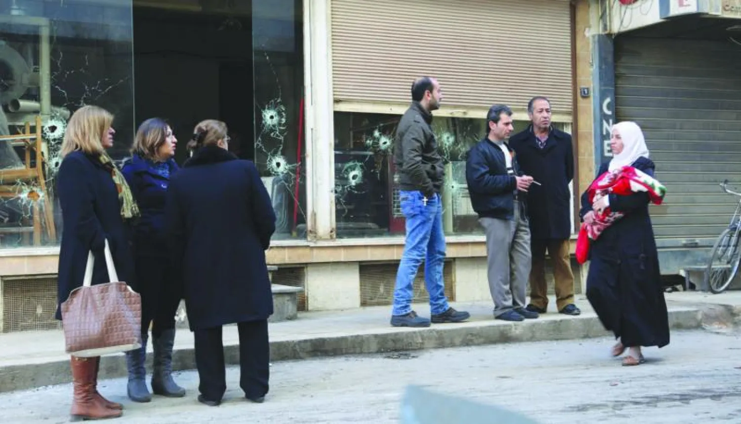 سوريون في حي بمدينة القامشلي شمال شرقي سوريا حيث اندلع قتال بين قوات كردية وسريانية في المدينة التابعة لمحافظة الحسكة (أ.ف.ب)