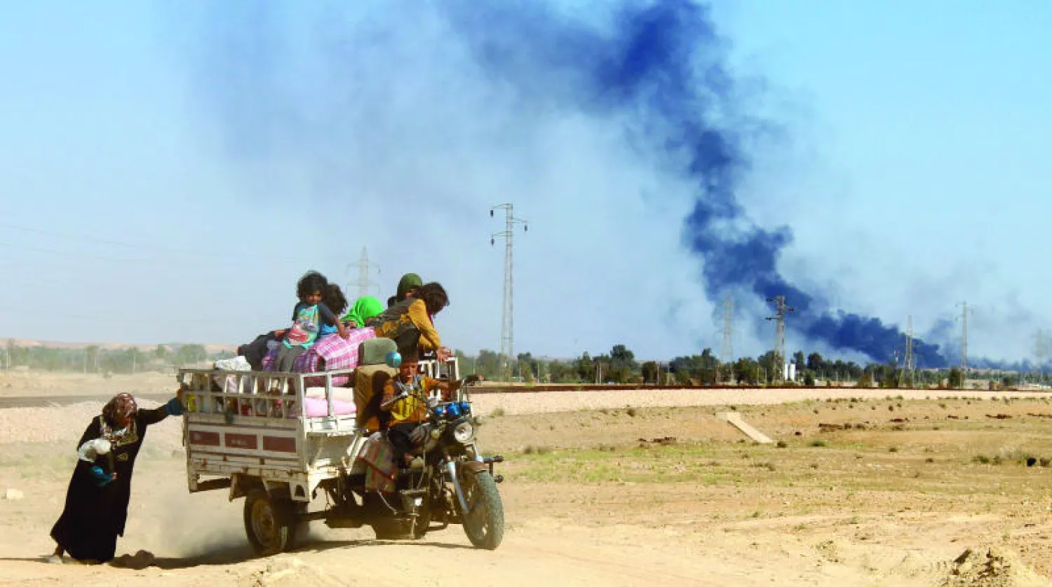 نازحون من هيت غرب الأنبار يغادرونها أول من أمس إلى مواقع آمنة مع استمرار المعارك لتطهير المدينة (أ.ف.ب)