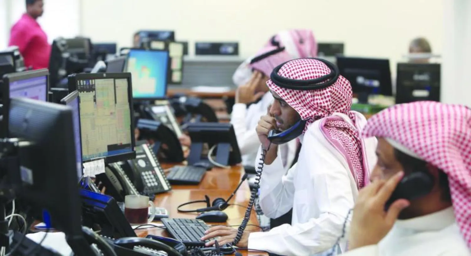 متعاملون يتابعون حركة الاسهم في سوق المال السعودي («الشرق الأوسط})