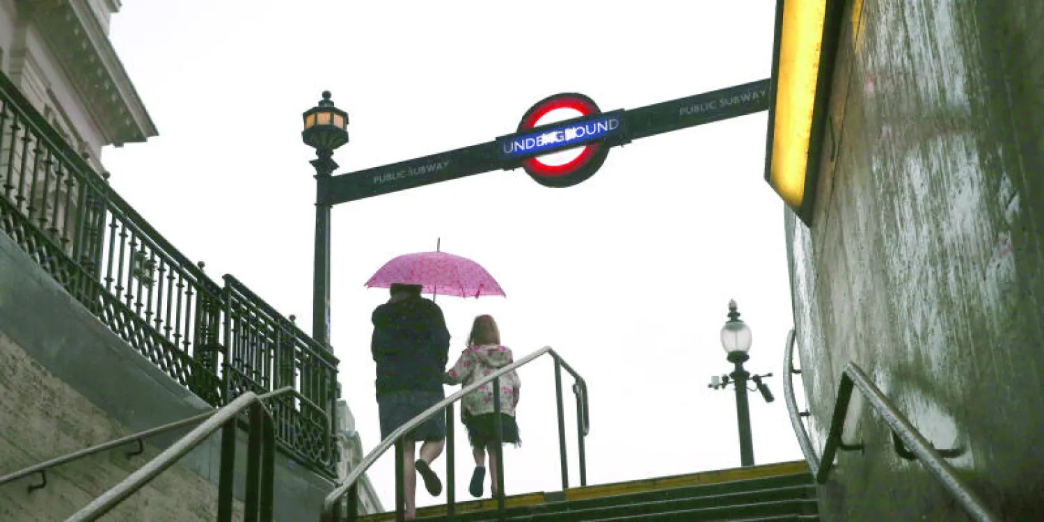 لقطة لمدخل محطة مترو بيكاديلي سيركس وسط العاصمة لندن وسط هطول أمطار غزيرة (غيتي)