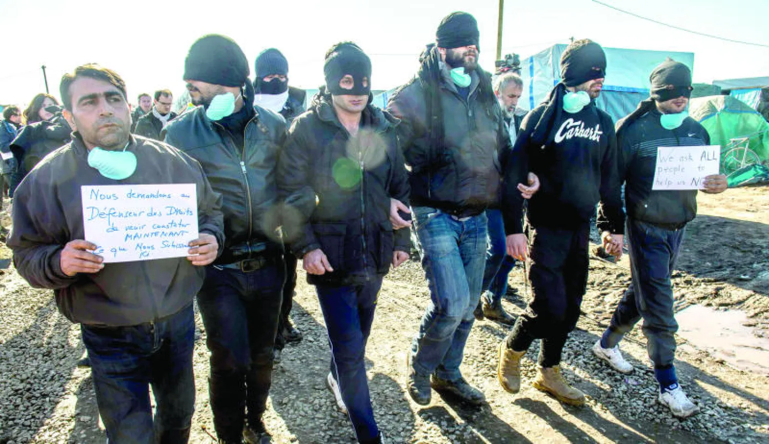 متظاهرون من المهاجرين الإيرانيين يحتجون على أوضاعهم في معسكر كاليه شمال فرنسا (أ.ف.ب)