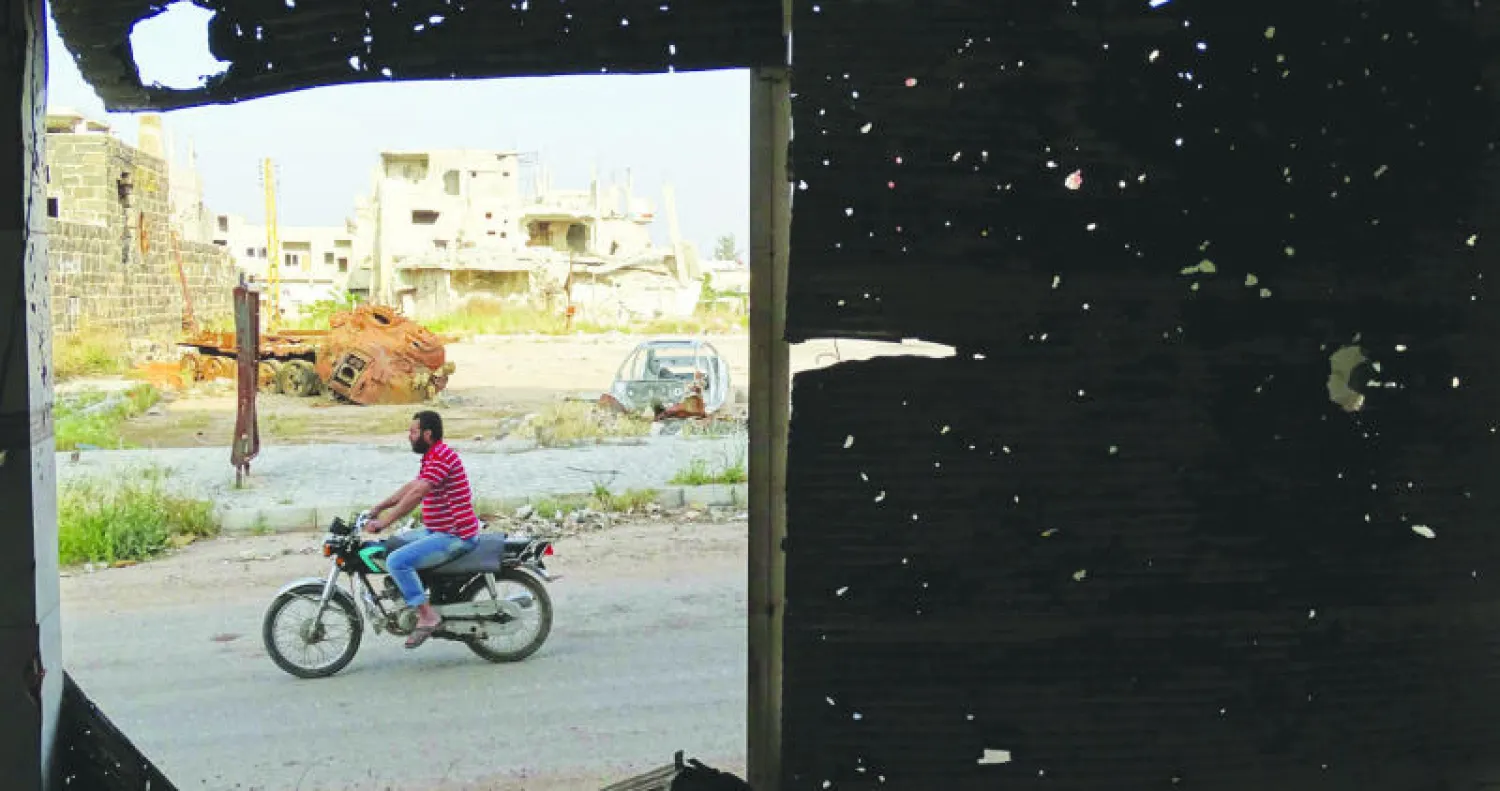 صورة التقطت من نافذة في درعا جنوب سوريا وتظهر أثار الرصاص على واجهة المبنى (رويترز)