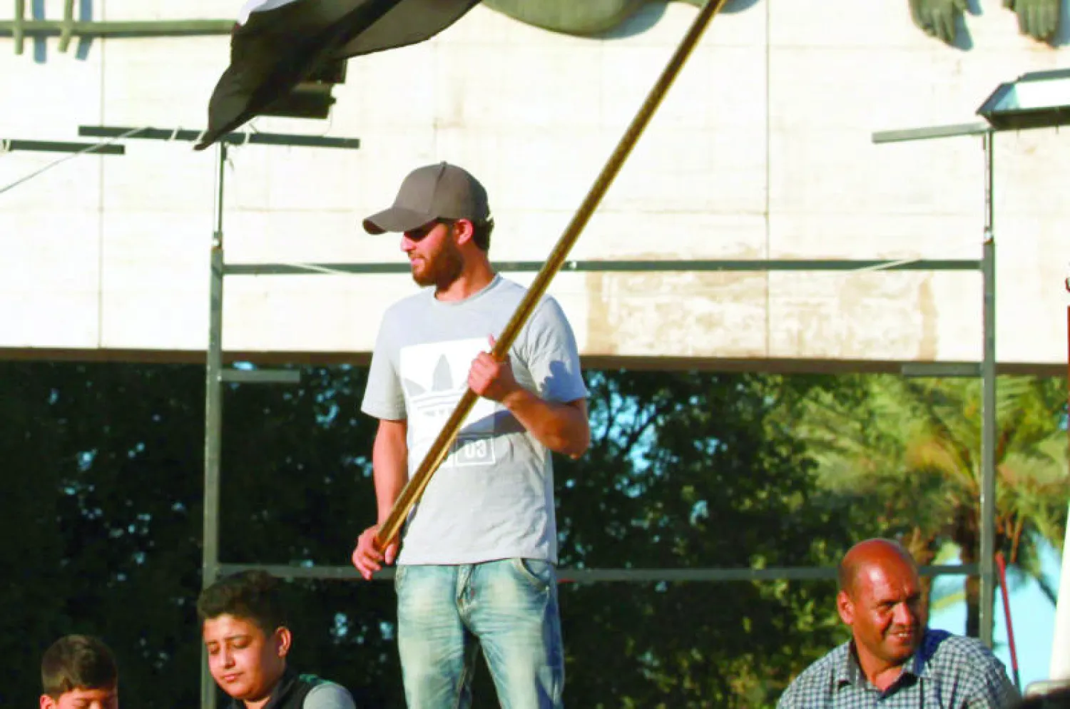 أحد أنصار رجل الدين الشيعي العراقي ورئيس التيار الصدري مقتدى الصدر يحمل العلم الوطني العراقي خلال اعتصام في ميدان التحرير وسط بغداد أول من أمس (أ.ب)