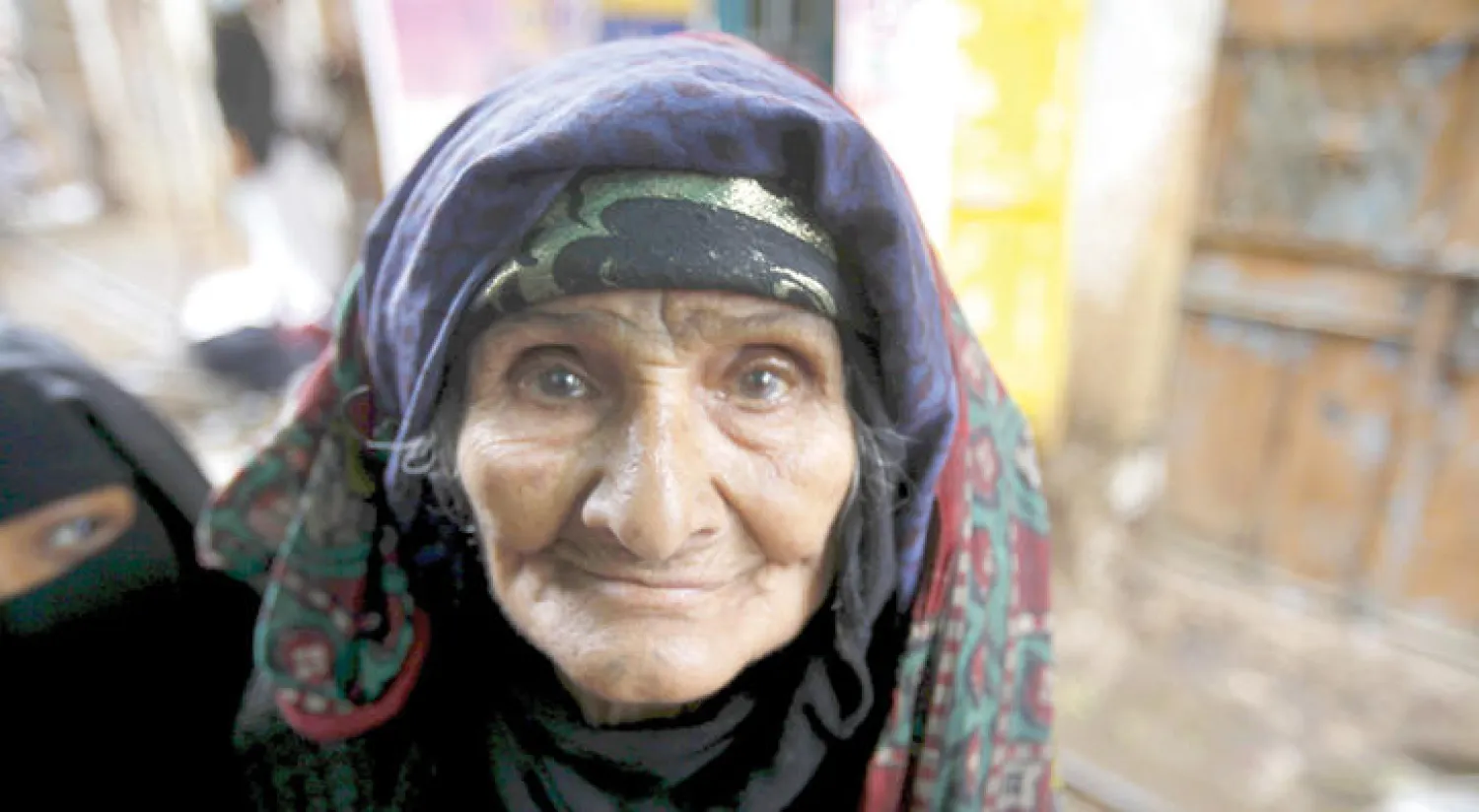 مسنة يمنية  تترقب الأوضاع الأمنية قبل تجولها بالحي القديم في العاصمة اليمنية صنعاء مساء أول من أمس (رويترز)