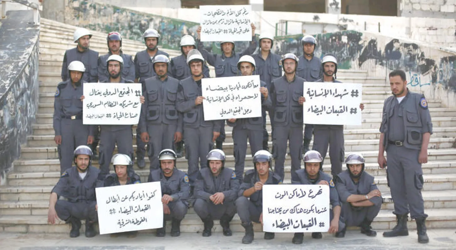 عناصر من قوات الدفاع المدني (القبعات البيض) التي تعمل بمناطق المعارضة في سوريا، في وقفة احتجاج صامتة امسعلى مقتل خمسة من رفاقهم في بلدة الاتارب بريف حلب قبل يومين (إ ب أ)