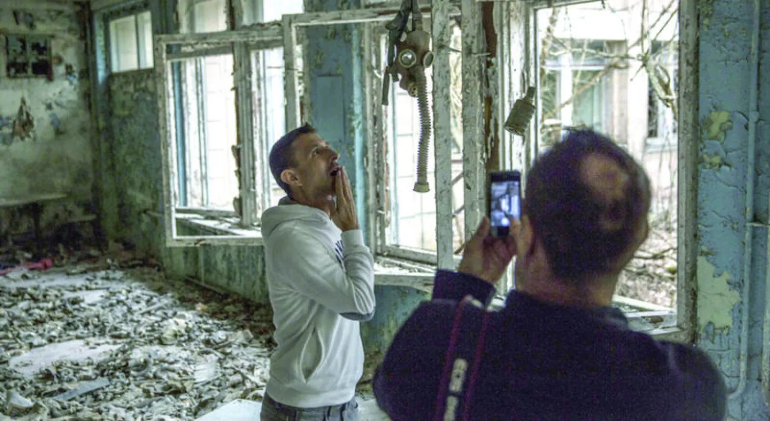 أوكرانيون يزورون مبنى كان مدرسة في منطقة تشيرنوبيل المحظورة (نيويورك تايمز)