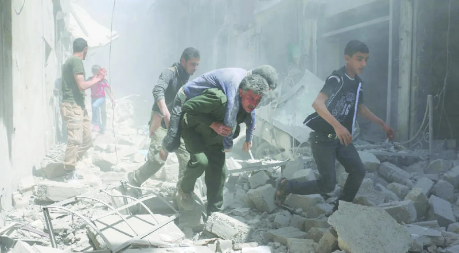 سوريون ينقذون سكانًا مدنيين من مبان دمرتها غارات الطيران الحربي للنظام في حي القاطرجي بحلب (أ.ف.ب)