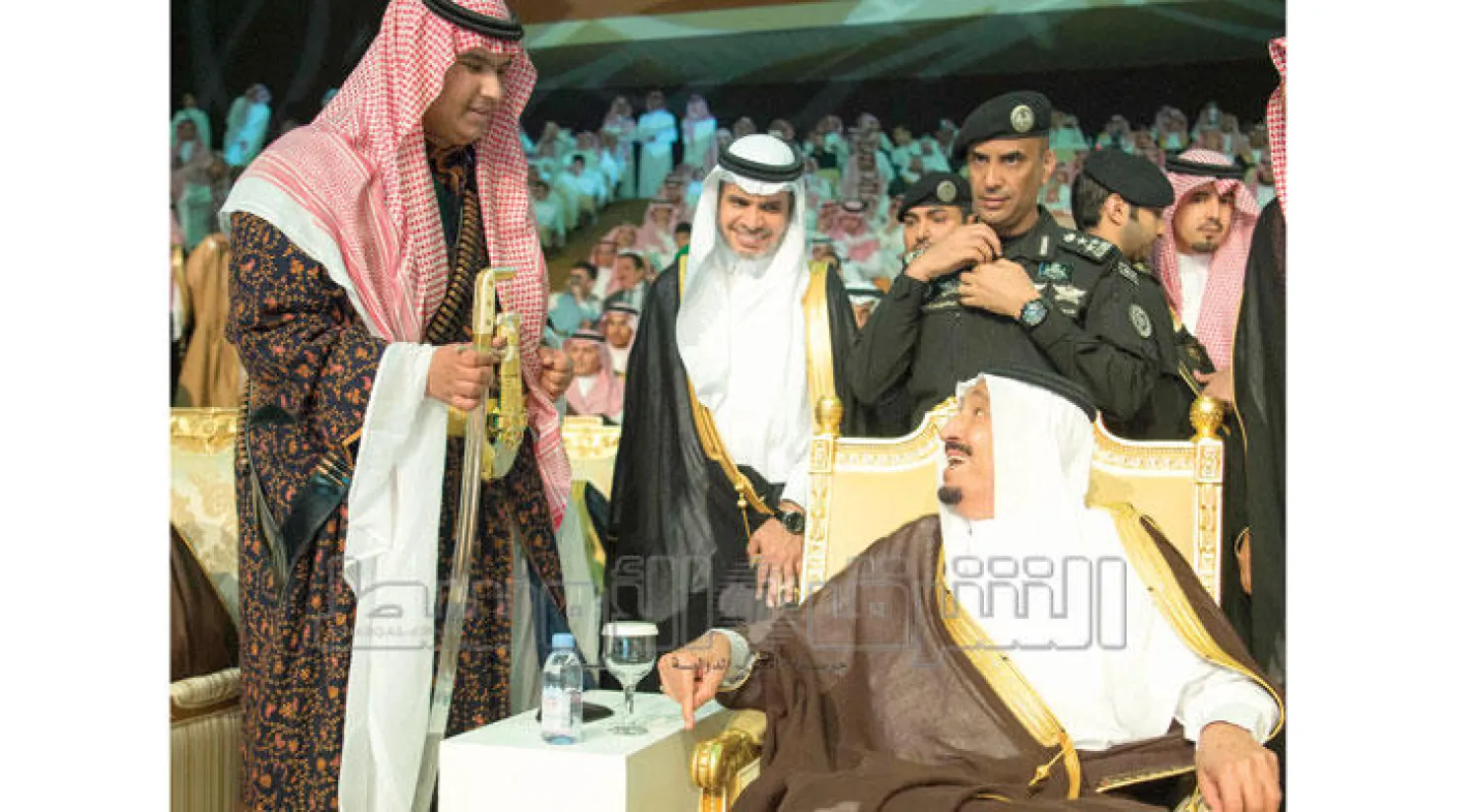 الملك سلمان في حديث باسم مع نجله الأمير راكان في حفل التخرج أمس .. ويبدو وزير التعليم أحمد العيسى (تصوير: بندر الجلعود)