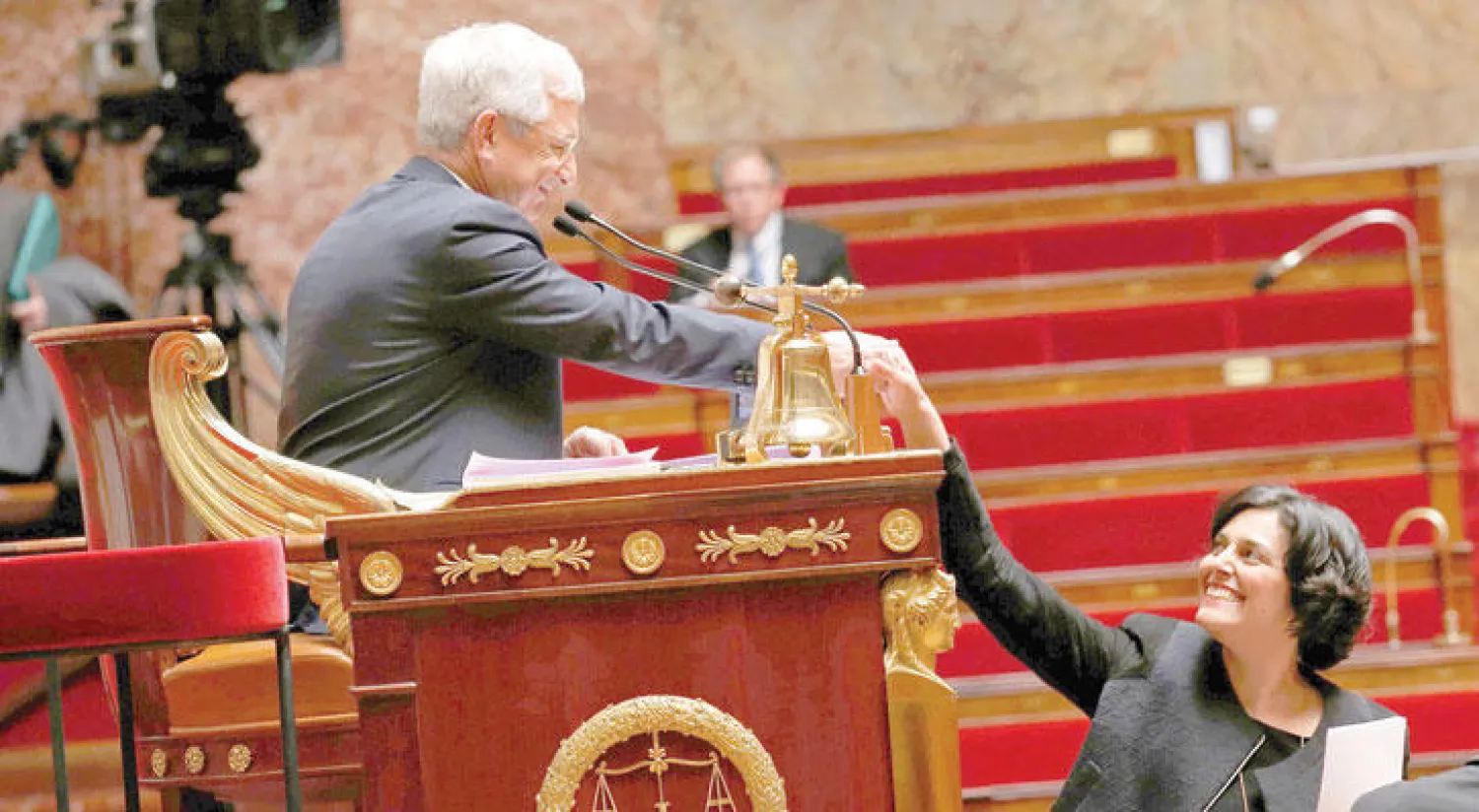 وزيرة العمل الفرنسية مريم الخمري تصافح رئيس المجلس الوطني الفرنسي كلود بارتولون خلال جلسة برلمانية لمناقشة إصلاح قانون العمل أمس في باريس (رويترز)