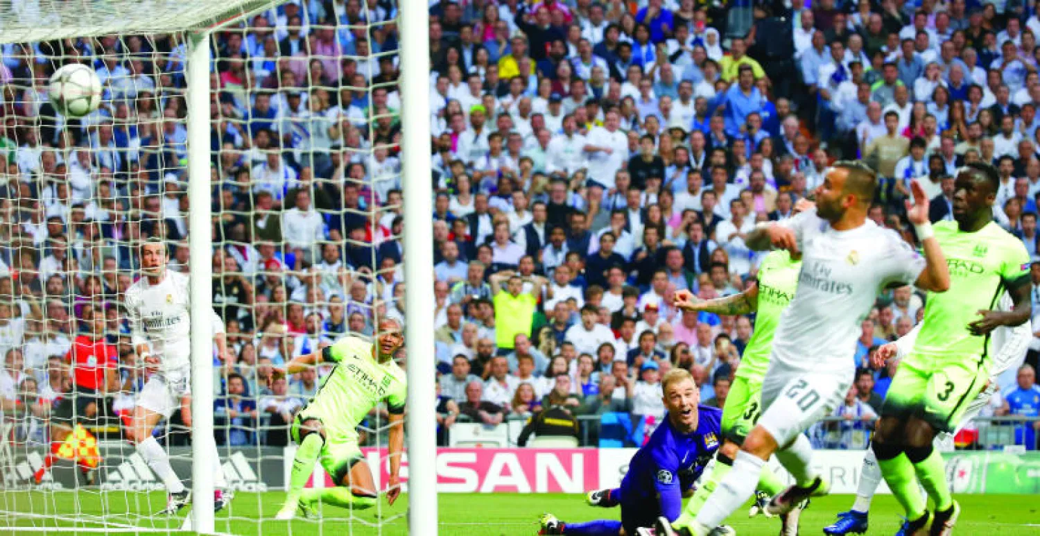 جو هارت حارس سيتي يراقب بيأس كرة غاريث بيل لاعب الريال (يسار) التي تحولت من قدم فريناند لتسكن شباكه (رويترز)