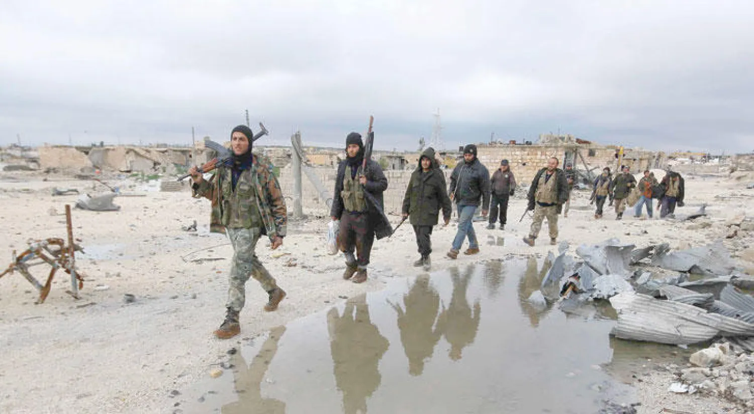 مقاتلون تابعون للمعارضة السورية يسيرون في منطقة مناشر حجر التابعة لحلب في صورة تعود للعام الماضي «رويترز»