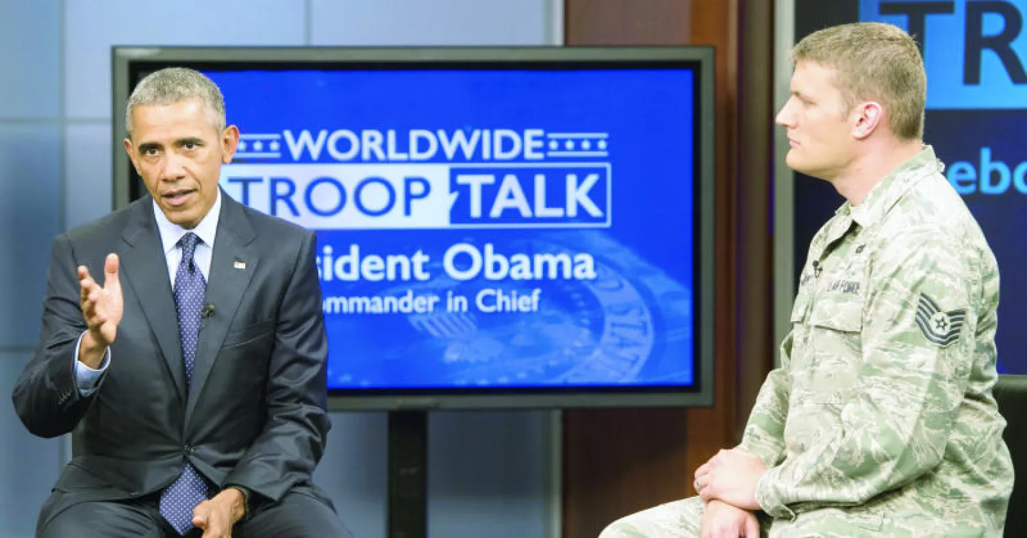 الرئيس الأميركي باراك أوباما يتحدث إلى المسؤول العسكري ناثان باري خلال حلقة نقاش عقد في 11 سبتمبر من العام الماضي بمبنى بلدية ولاية ماريلاند ( غيتي)