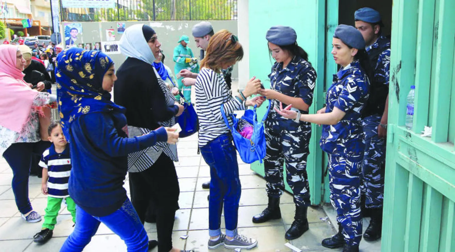 شرطيات لبنانيات يفحصن أوراقا ثبوتية لناخبات قبل دخولهن أحد مراكز الاقتراع في بيروت أمس (إ. ب. أ)