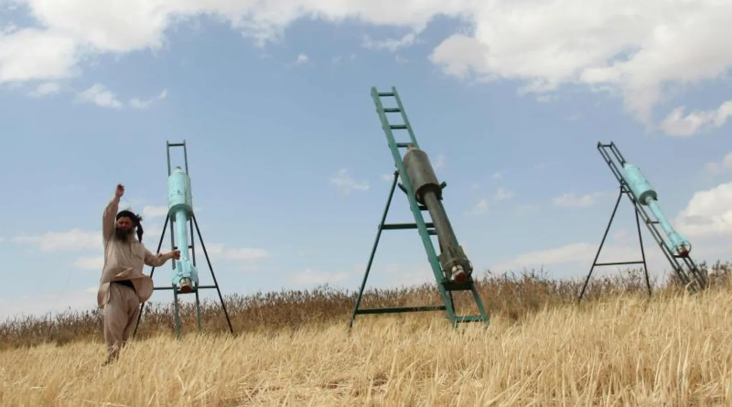 مقاتل من فصائل جيش الفتح الذي تشكل جبهة النصرة عنصرا اساسيا فيه يهيئ لاطلاق قذيفة ضد قوات الاسد في قرية ام الكراميل جنوب حلب (إ ف ب)