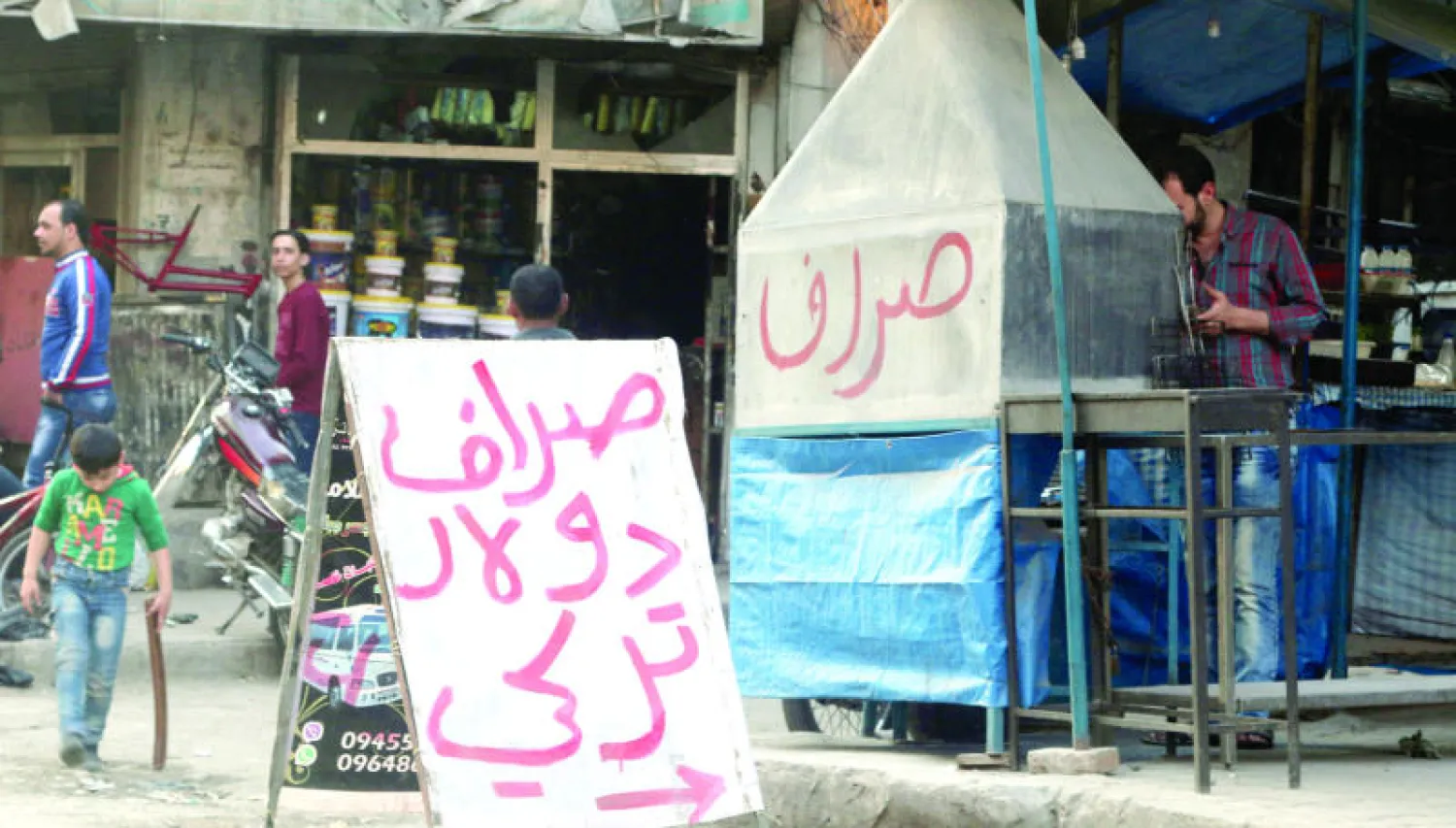 لافتة أمام محل صرافة في المنطقة الخاضعة لسيطرة المعارضة في مدينة حلب شمال سوريا (رويترز)