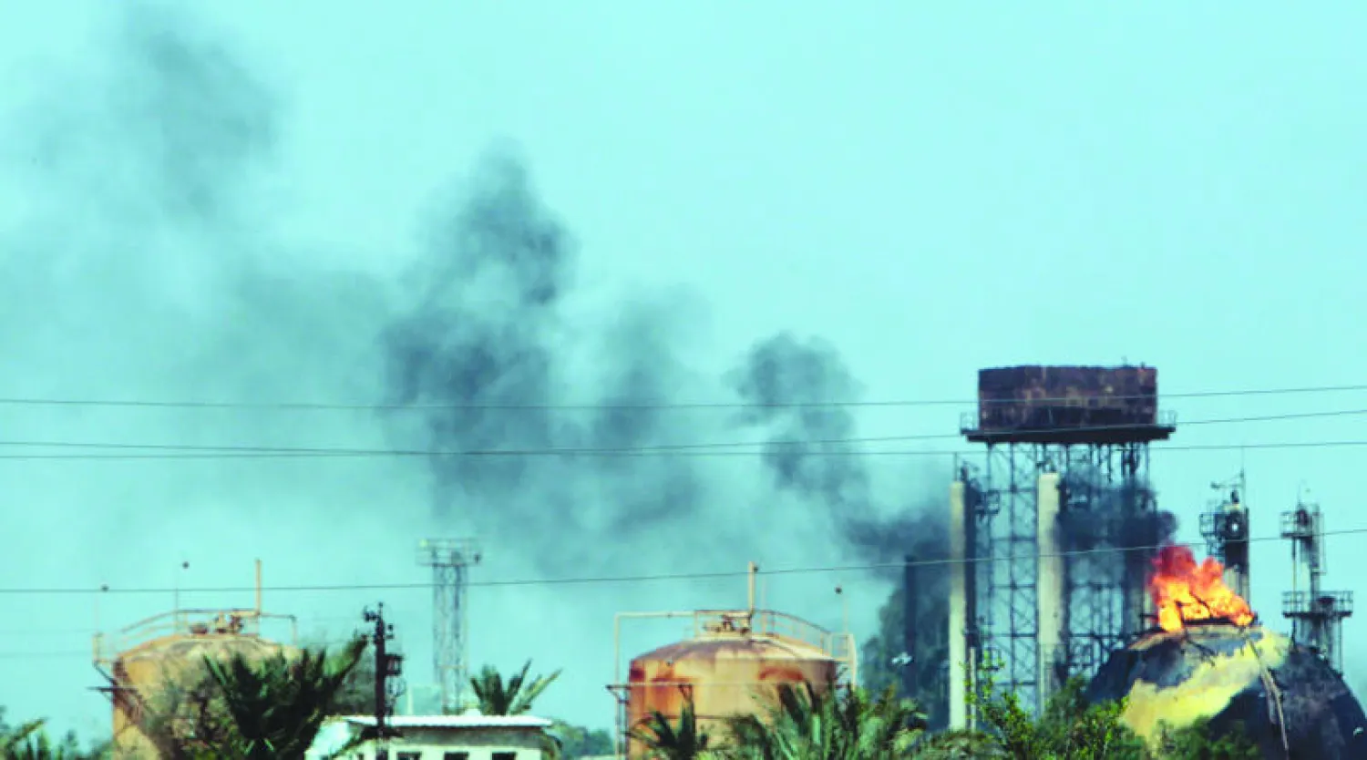الأدخنة تتصاعد من معمل إنتاج الغاز إثر الهجوم الانتحاري في شمال بغداد أمس (أ.ف.ب)