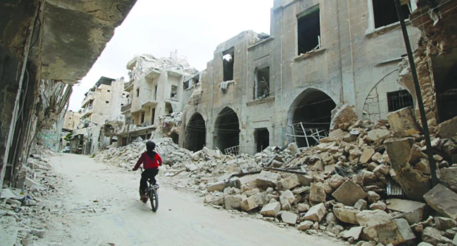 طفل يعبر الأبنية المتهدمة نتيجة غارات الطيران على مناطق المعارضة في حلب (رويترز)