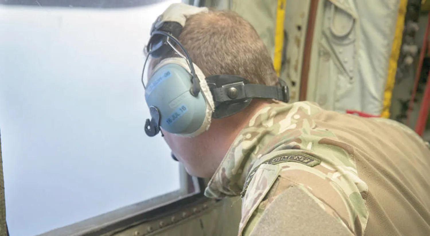 ضابط في البحرية البريطانية ينظر عبر نافذة طائرة للنقل العسكري من طراز «سي-130 هيركوليس»  خلال عملية بحث عن الطائرة المصرية المنكوبة في شرق المتوسط (إ.ب.أ)