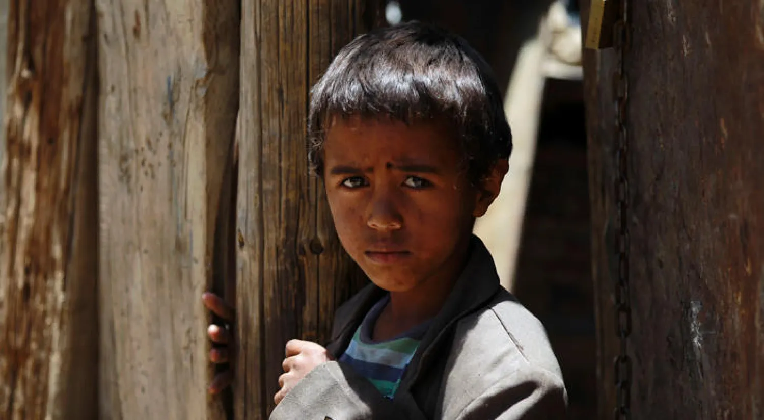 طفل يمني خارج بيته الواقع في إحدى العشوائيات بصنعاء (أ.ف.ب)