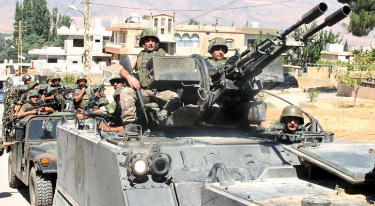 عسكريون لبنانيون فوق ناقلة يتوجهون إلى عرسال على الحدود مع سوريا (أ.ف.ب)