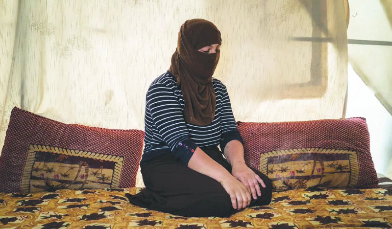 فتاة إيزيدية نجحت في الفرار من قبضة «داعش».. وتبدو جالسة في خيمة خارج دهوك بالعراق («واشنطن بوست»)