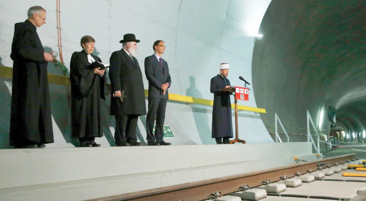 رجال دين يمثلون الديانات الثلاث خلال حفل افتتاح أطول نفق للسكك الحديدية (إ.ب.أ)