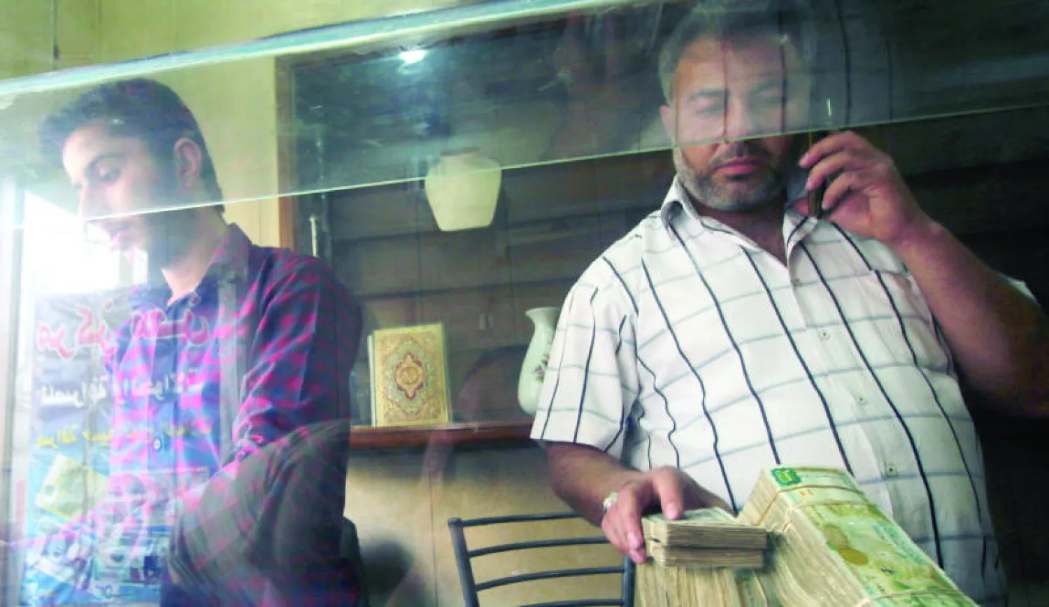 صراف عملات أجنبية داخل محله في القسم الشرقي من حلب منتصف الشهر الماضي (رويترز)