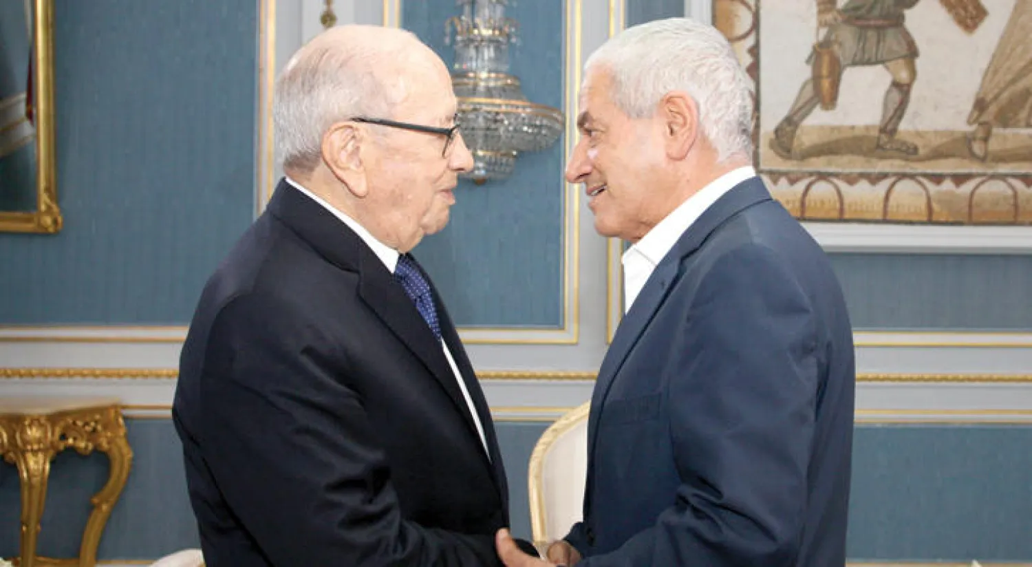 الرئيس التونسي الباجي قائد السبسي يصافح أحد الحائزين جائزة نوبل للسلام للجنة الرباعية للحوار الوطني التونسية، الأمين العام للاتحاد العام للعمل التونسي، حسين عباسي، عقب اجتماع في العاصمة تونس أمس (أ.ف.ب)