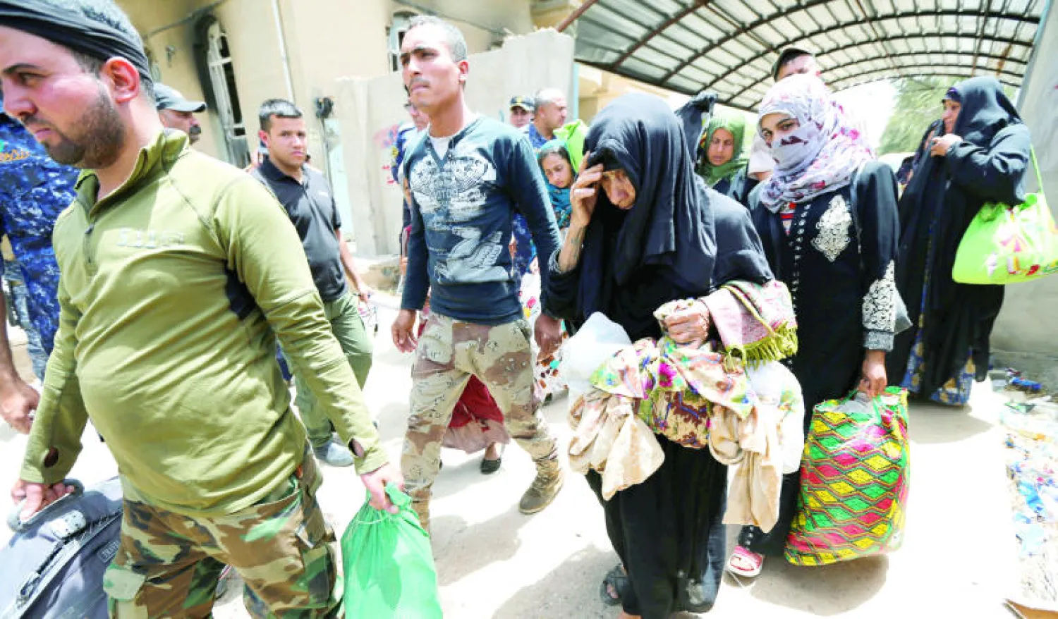 مدنيون عراقيون يفرون من منازلهم إثر الأحداث الدامية التي عرفتها ناحية الصقلاوية شمال الفلوجة (رويترز)