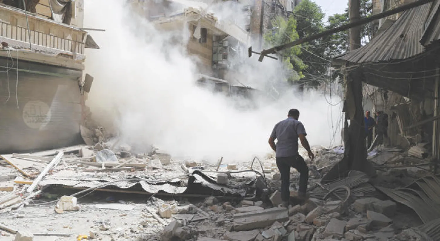 رجل يسير عبر ركام المباني في أعقاب غارة لطيران النظام السوري أمس على حي القاطرجي شرقي حلب (أ.ف.ب)
