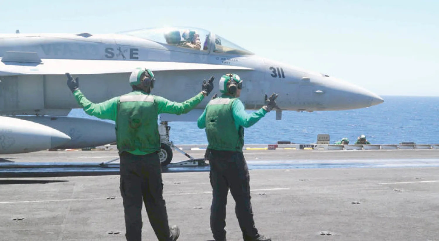 جنديان من البحرية الأميركية يساعدان على إطلاق مقاتلة من على ظهر حاملة الطائرات {هاري ترومان} في شرق المتوسط الثلاثاء الماضي (أ.ف.ب)