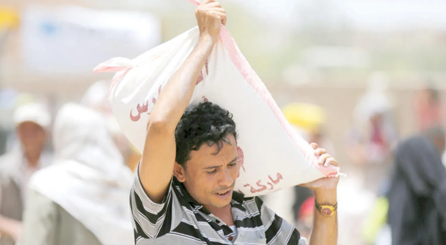 أحد سكان صنعاء يحمل مساعدات إغاثية قدمت له من مؤسسة خيرية محلية (رويترز)