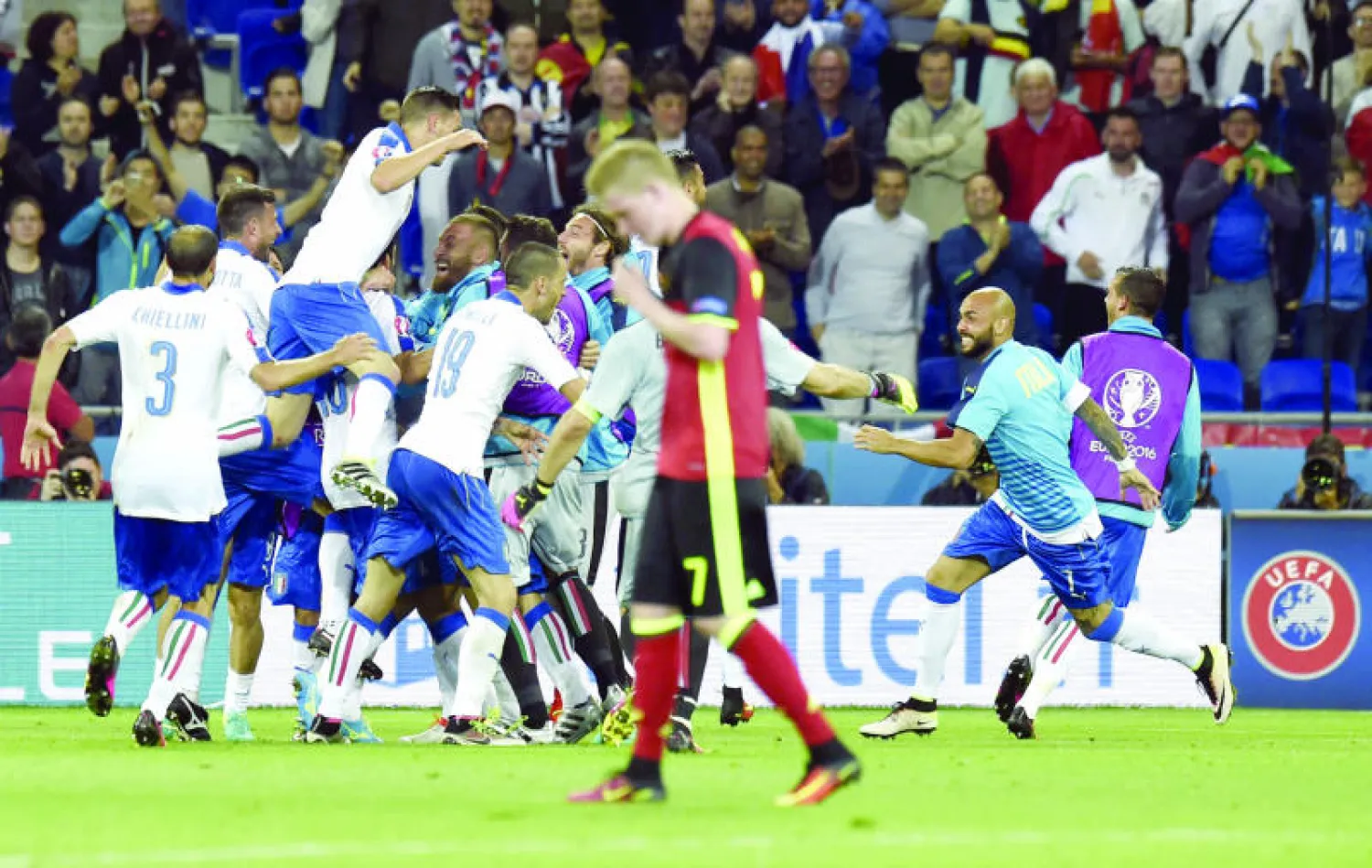 لاعبو إيطاليا يحتفلون بالفوز.. بينما الحسرة بادية على دي بروين مهاجم بلجيكا (أ.ف.ب)