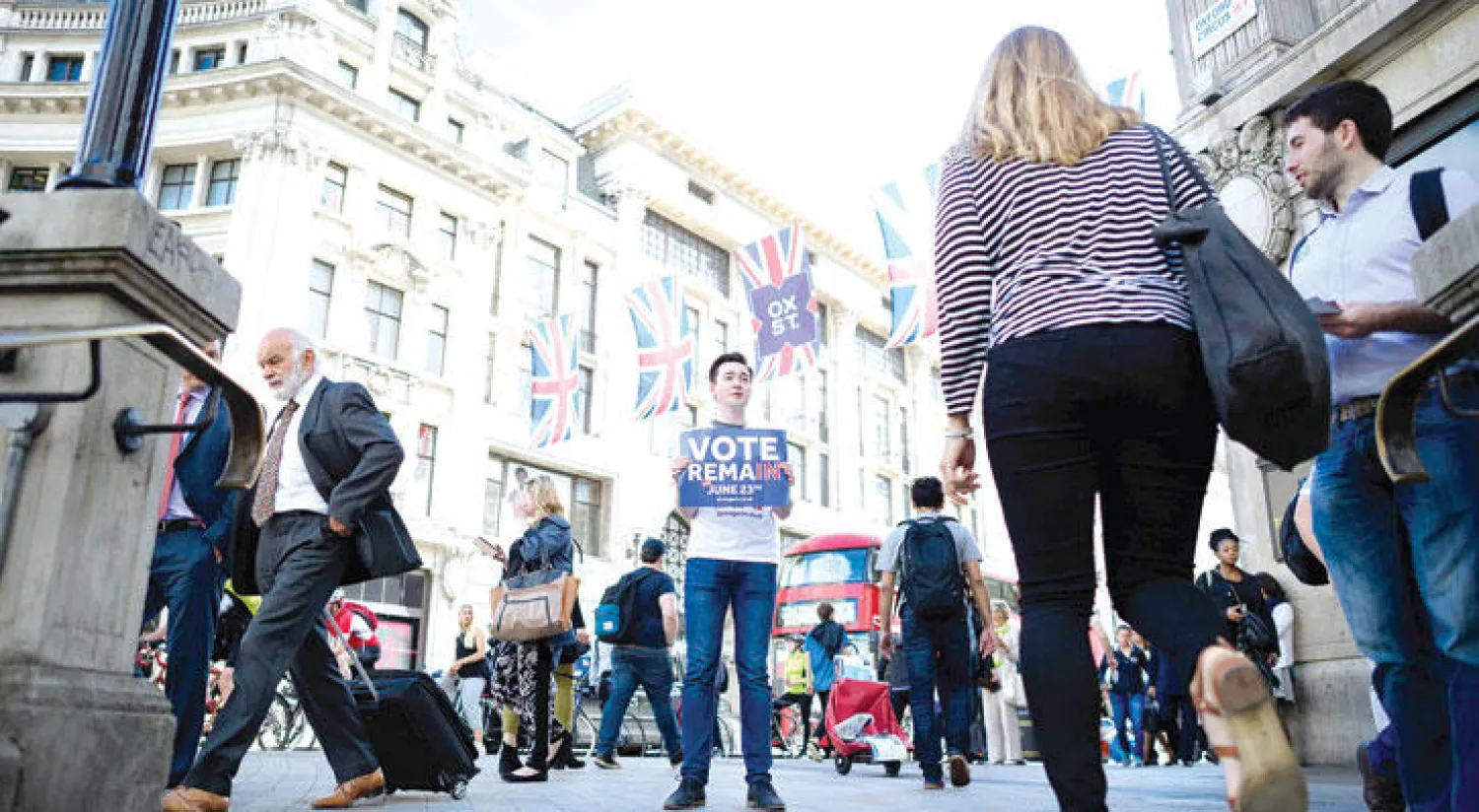 شاب يرفع ملصقا مؤيداً لبقاء بريطانيا ضمن الاتحاد الأوروبي في شارع أكسفورد في وسط لندن (أ.ف.ب)